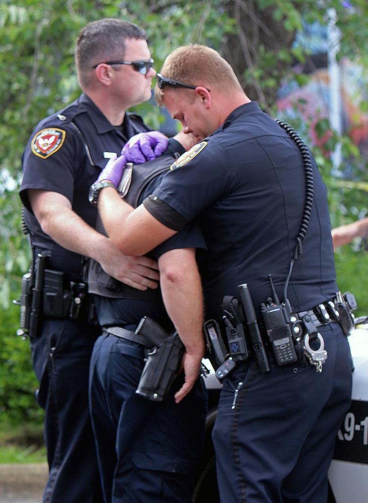 Durham police officers, from left, B. Taylor, B. Johnson and R. Preston console each other Sunday, June 4, 2017 at the shooting scene on Hillandale Road in Durham. 7-year-old Kamari Munerlyn died from a gunshot wound.