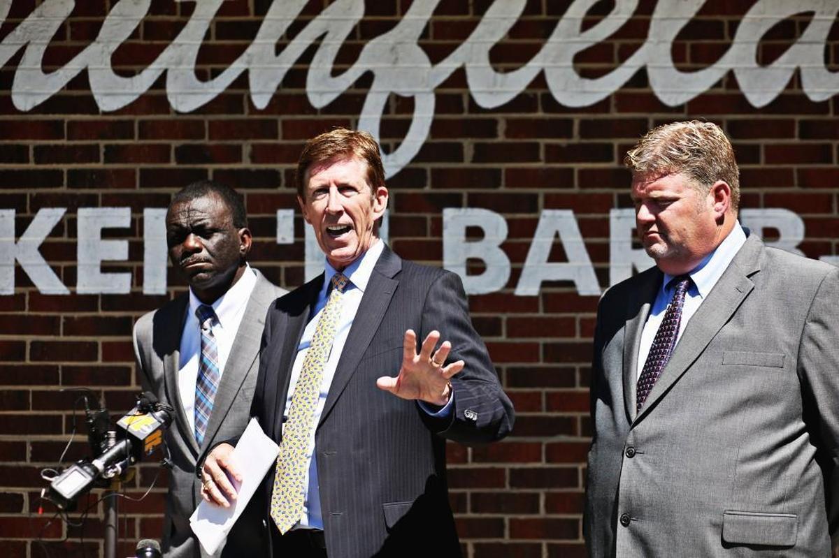 Mark O’Mara, center, the attorney for Smithfield’s Chicken ’n Bar-B-Q, talks with the media alongside franchisee David Harris, right, and store manager Willie McKennies, left, during Wednesday’s news conference at the restaurant.