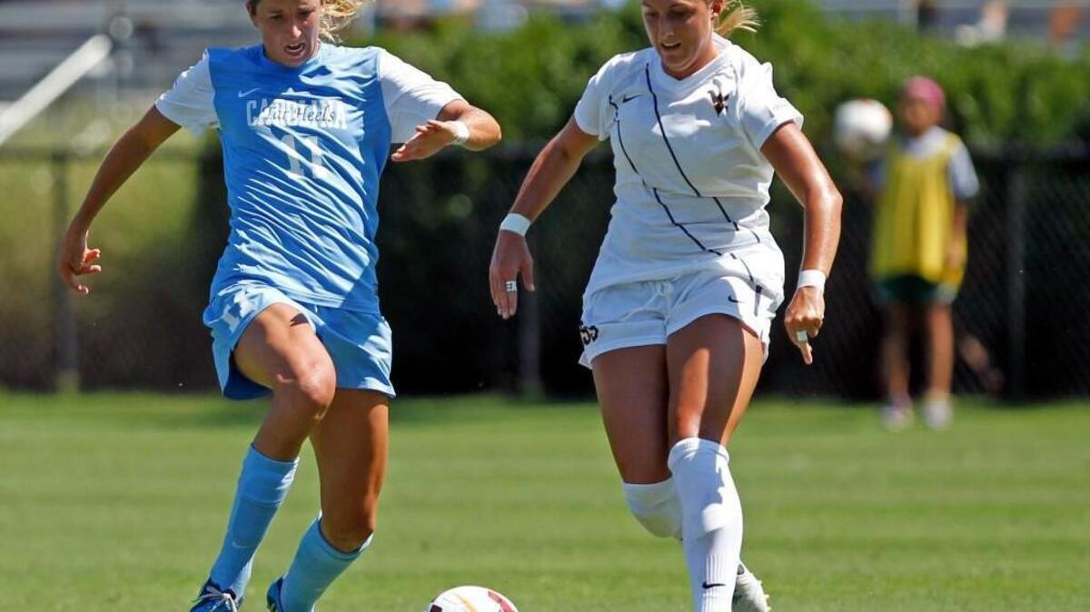 UNC senior midfielder Kelly McFarlane, left, races for ball against West Virginia's Kate Schwindel in the second period during the Duke Nike Classic women's soccer tournament at Koskinen Stadium in Durham, N.C. on Sunday, September 8, 2013.