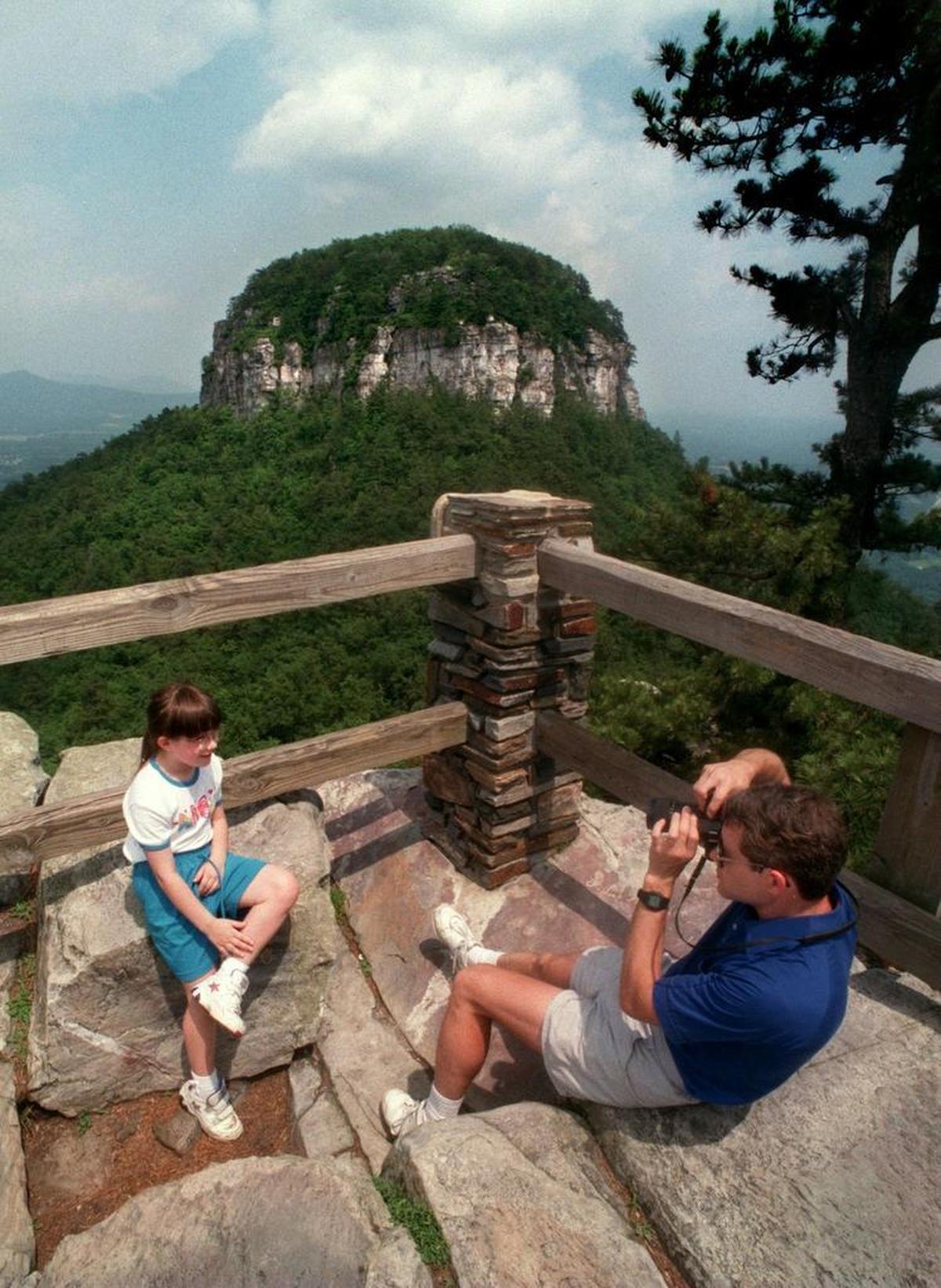 Andrew Glaid takes a picture of his seven-year-old daughter, Michelle, at the vista of Pilot Mountain State Park outside of Mount Airy in July 2017.