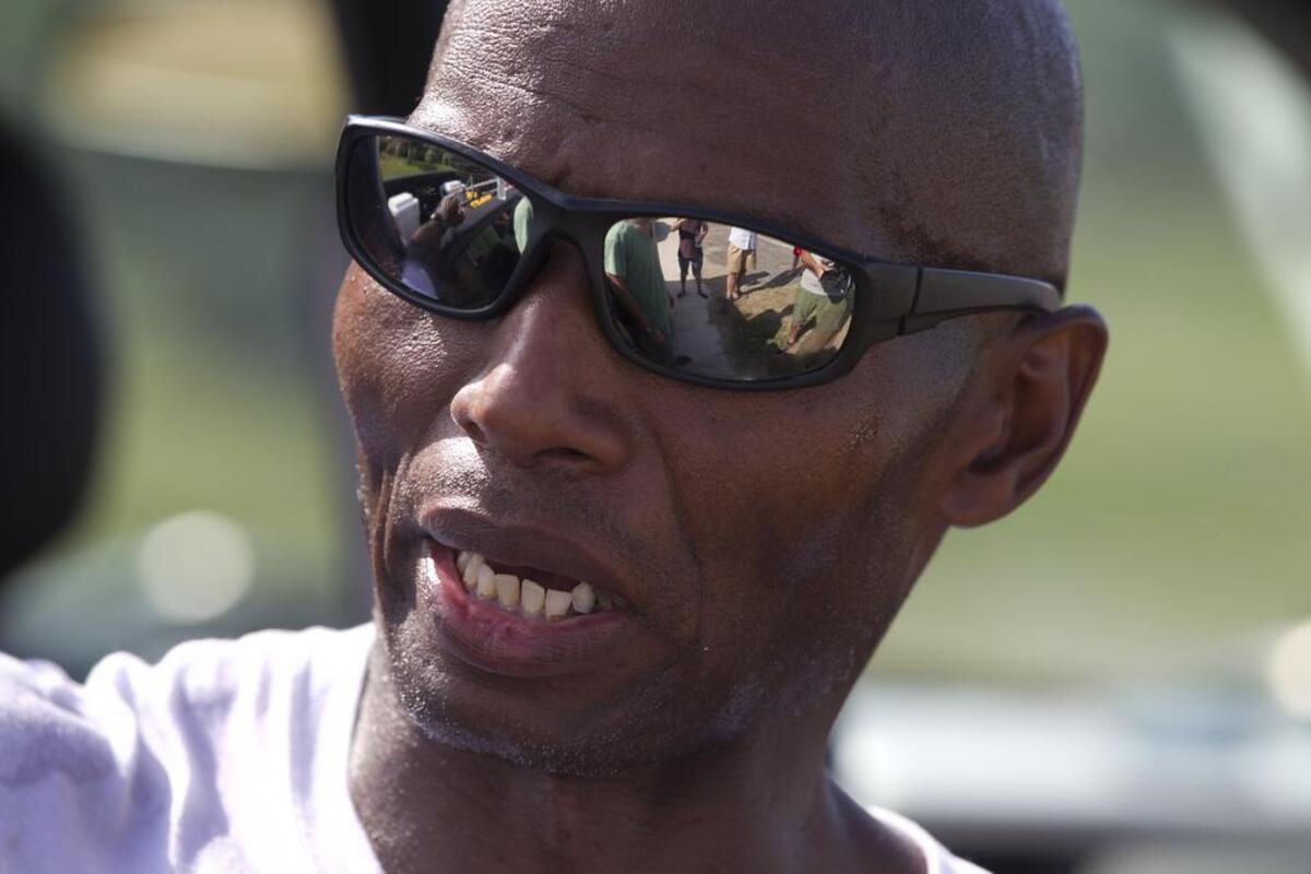 Rodney Hines of Raleigh, N.C, the “No-Hand King,” takes a break after cramping in his legs forced him to stop his trek from Nags Head to Buxton along NC 12 on Tuesday June 16, 2015.