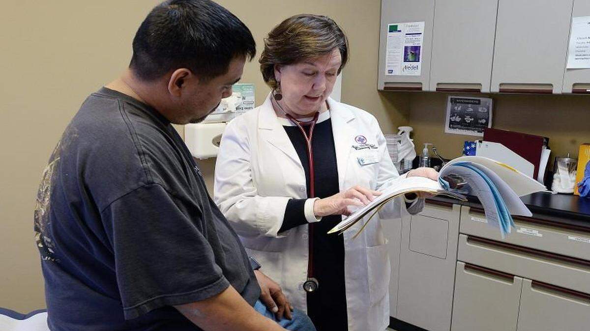 In this file photo family nurse practitioner, Anne Potter, reviews a patient’s medical chart during his examination at HealthReach Community Clinic, a free health care clinic in Mooresville, NC. 