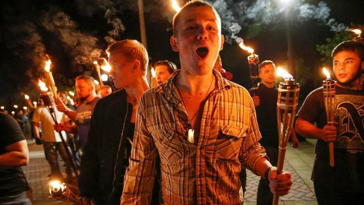 In this photo taken Friday, Aug. 11, 2017, multiple white nationalist groups march with torches through the UVA campus in Charlottesville, Va. Hundreds of people chanted, threw punches, hurled water bottles and unleashed chemical sprays on each other Saturday after violence erupted at a white nationalist rally in Virginia.