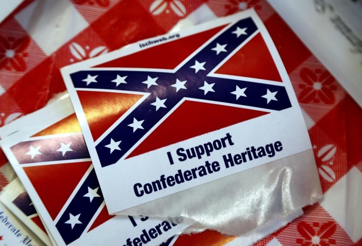The Sons of Confederate veterans sell Confederate merchandise, give away stickers of the battle flag and talk about Southern history at the N.C. State Fair in Raleigh on Oct. 19, 2017. Volunteers working at the booth say they give away thousands of the stickers every day.