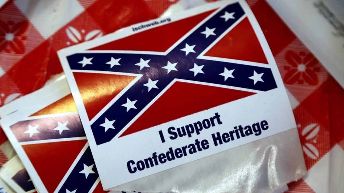 The Sons of Confederate veterans sell Confederate merchandise, give away stickers of the battle flag and talk about Southern history at the N.C. State Fair in Raleigh on Oct. 19, 2017. Volunteers working at the booth say they give away thousands of the stickers every day.