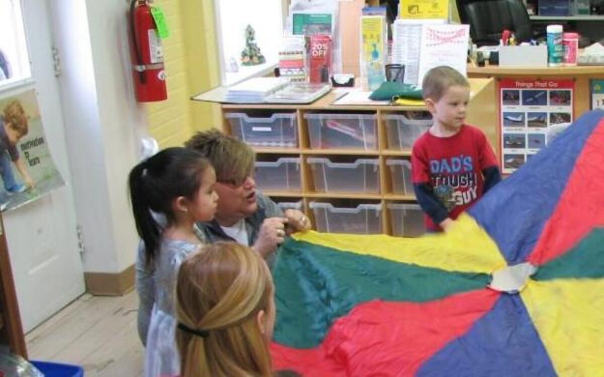 Kids play around a parachute at the East Wake Education Foundation, which helps children in Wendell, Zebulon and Knightdale prepare for school.