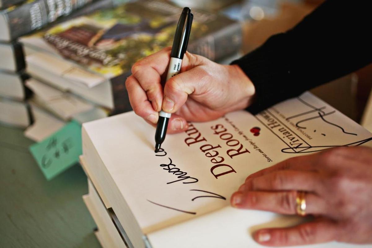 “I do a lot of this,” says chef Vivian Howard as she signs several of her cookbooks, “Deep Run Roots,” at her test kitchen in downtown Kinston, Nov. 15, 2017.