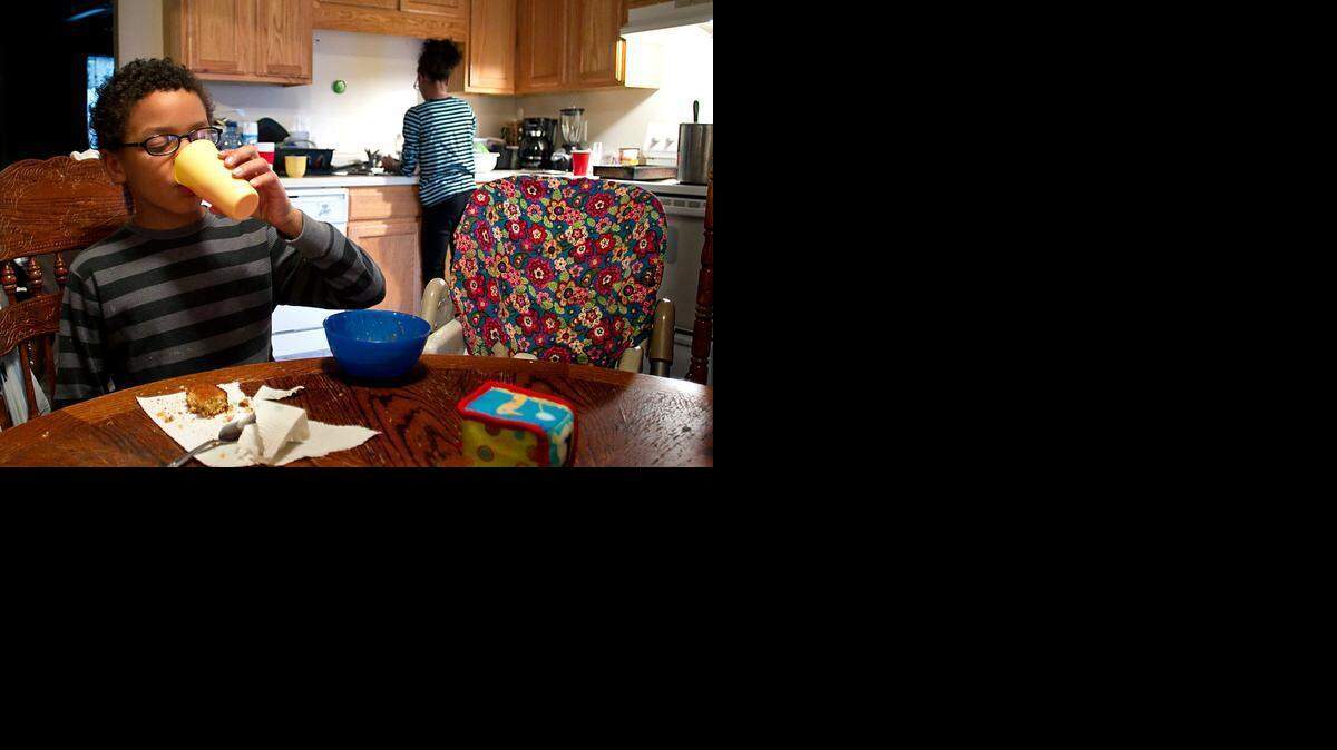 
Jordan Jones, 8, finishes his meal of bean soup and cornbread at home on Friday.  His mother, Joyce Todd-Jones, has struggled with her food budget the past two weeks, having to feed her children extra meals at home during snow days off from school. Her family relies on the free or reduced breakfast and lunch programs at school.

