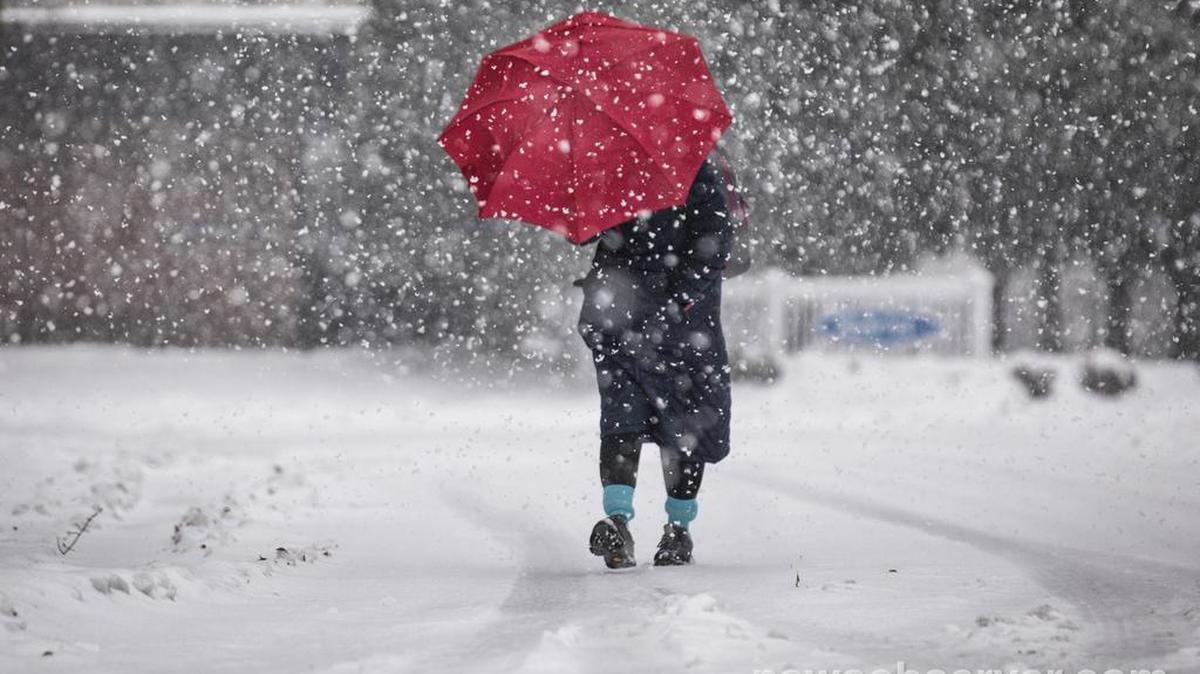 A Carrboro resident walks towards downtown as snow comes down on Monday morning, Dec. 10, 2018.