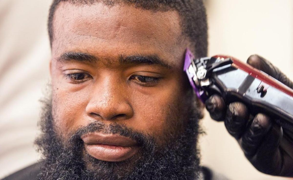 “I appreciate his work,” said Cliff Jarman, who is homeless, after receiving a free haircut from William Winters, who used to be homeless and now owns Mr. GroomRoom Barber Shop in Raleigh.