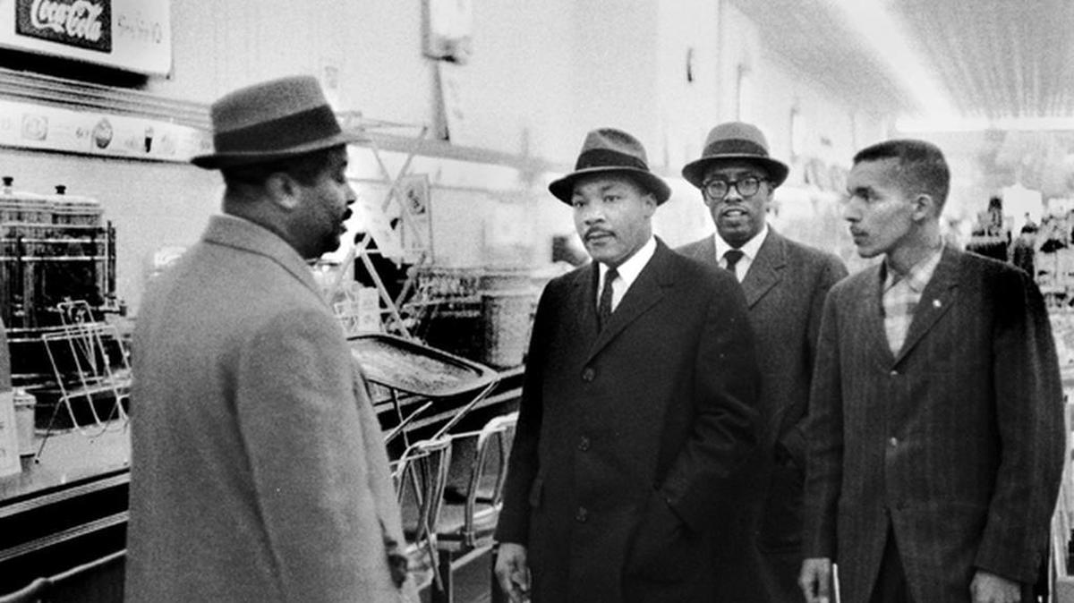 Pictured from left, Ralph Abernathy, the Rev. Martin Luther King Jr., Asbury Temple Methodist Church pastor Rev. Douglas Moore and N.C. Central University student Lacy Streeter visit the then-segregated lunch counter at Woolworth’s in downtown Durham on Feb. 16, 1960.