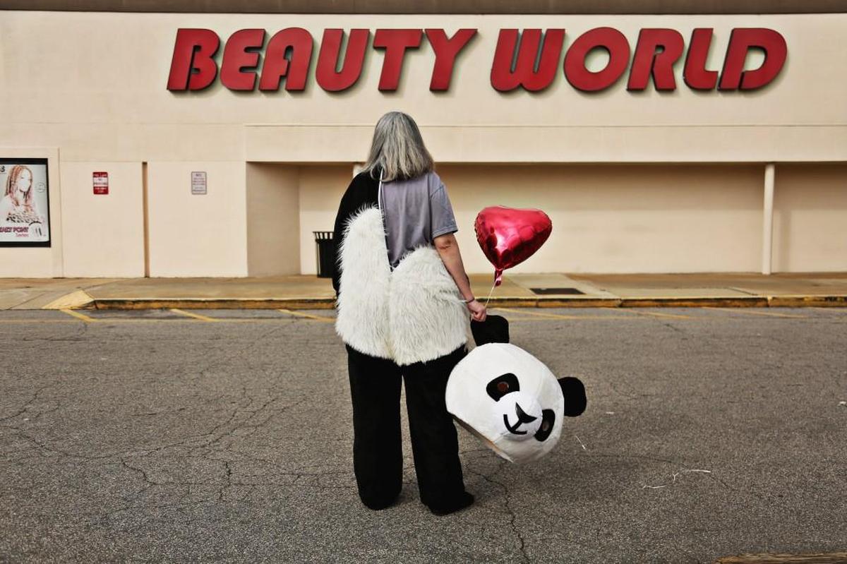 Cydney Graham, dressed in a panda costume, waits until the last minute to zip up and put on the head outside of Beauty World in Garner on Feb. 21, 2018. Graham collaborates on the Instagram art project, Sideshow Panda, with her boyfriend, Bryan Regan, who is a professional photographer.