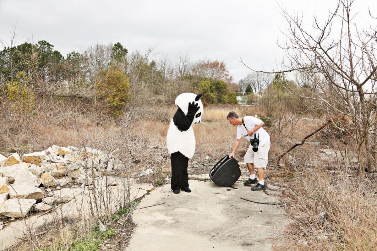 Photographer Bryan Regan, right, drags an old TV beside his girlfriend, Cydney Graham, dressed as a panda, for a photo in a vacant lot in Raleigh on Feb. 21, 2018. The couple collaborate on the Instagram art project, Sideshow Panda, highlighting urban decay as well as anything else that catches their eyes.