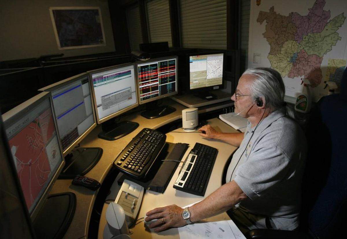 In this 2007 file photo, dispatcher Harold Guthrie takes a call which is automatically located on a computerized map (screen at far left) used by the Raleigh - Wake Emergency 911 center.