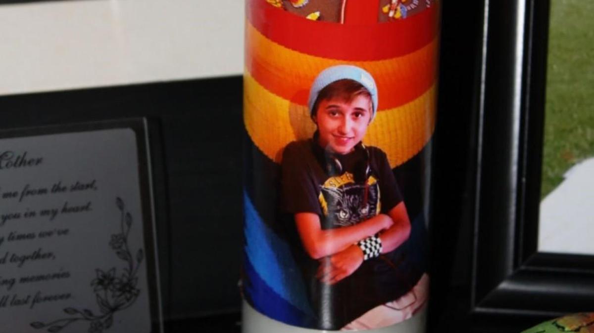 A memorial to Ash Haffner sits on a black cabinet in Ash’s mother’s new home — pictures, a candle, a letter from President Obama and tributes from friends.