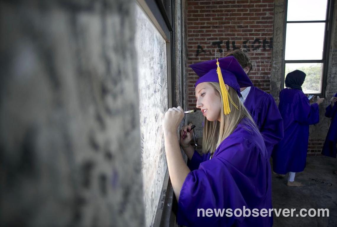 Broughton graduate Sydney Clark signs the window in the bell tower of the historic school following commencement exercise on Thursday, June 9, 2016 in Raleigh, N.C. Broughton is the only Wake County high school that holds its graduation on campus.