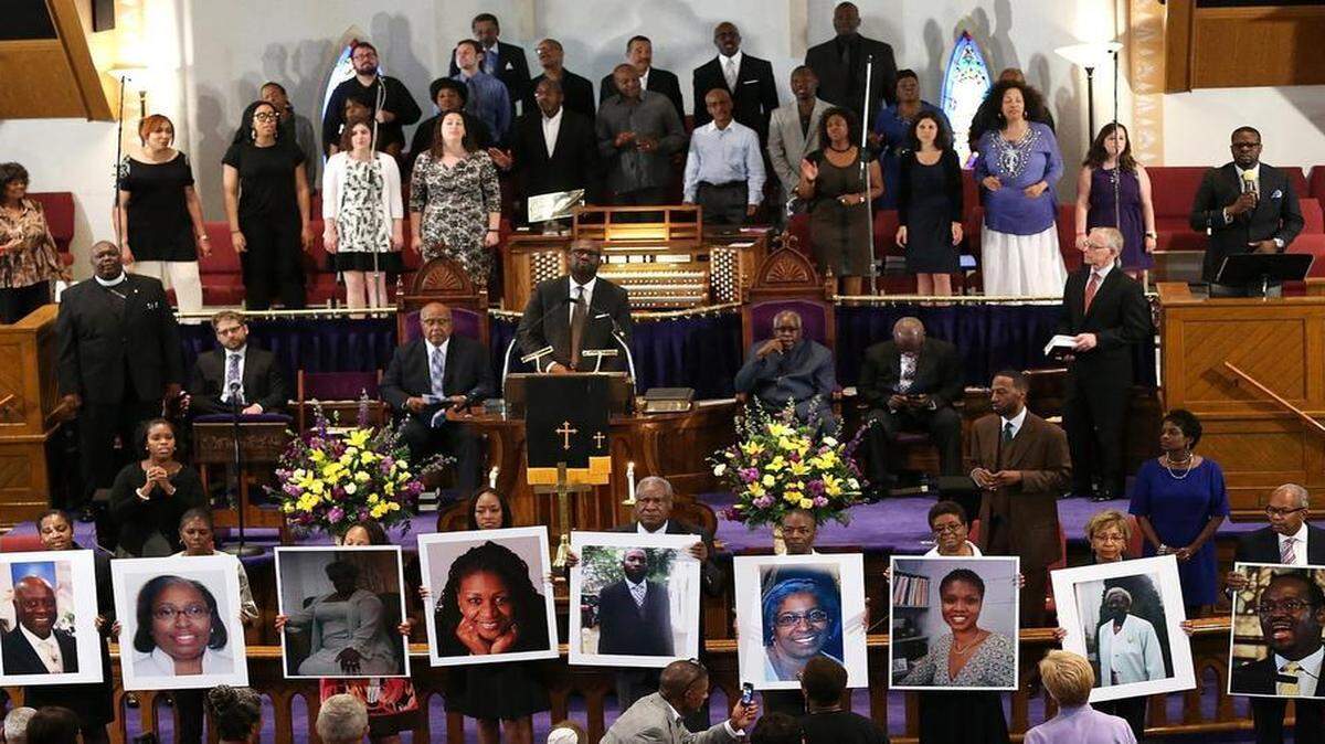 
Photographs of the nine victims killed at the Emanuel African Methodist Episcopal Church in Charleston, SC are held up by congregants during a prayer vigil at the the Metropolitan AME Church June 19, 2015 in Washington, DC. Earlier today the suspect in the case, Dylan Storm Roof, was charged with nine counts of murder. 
