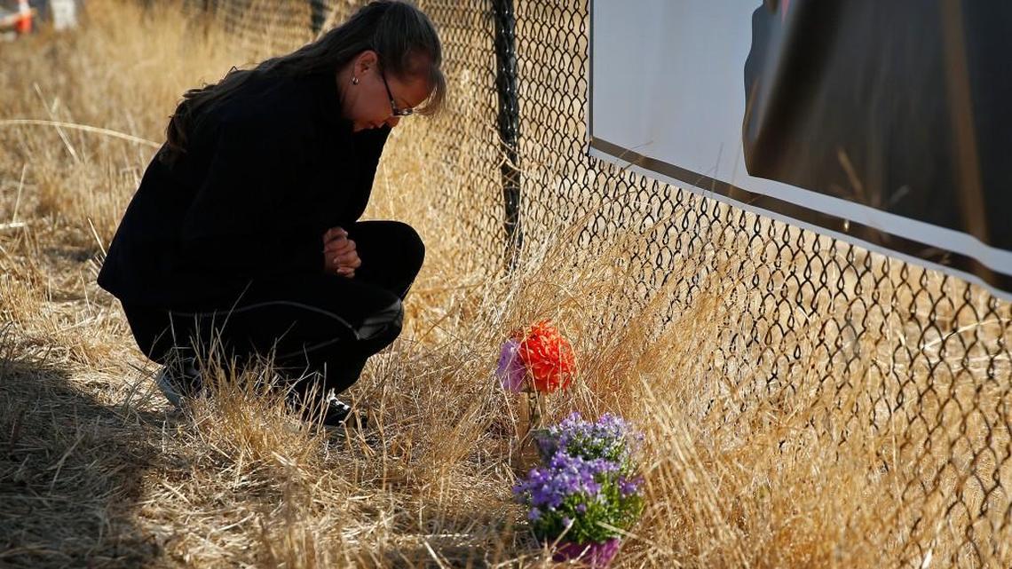 
Robin Griffiths, of Portland, prays at a makeshift memorial near the road leading to Umpqua Community College Saturday, Oct. 3, 2015, in Roseburg, Ore. 
