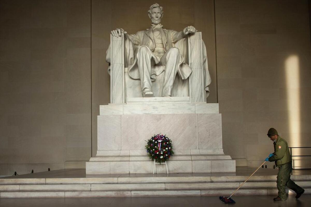 A US National Park employee cleans the floor of the Lincoln Memorial after a wreath-laying ceremony to honor Abraham Lincoln's 207th birthday February 12, 2016 in Washington, DC.