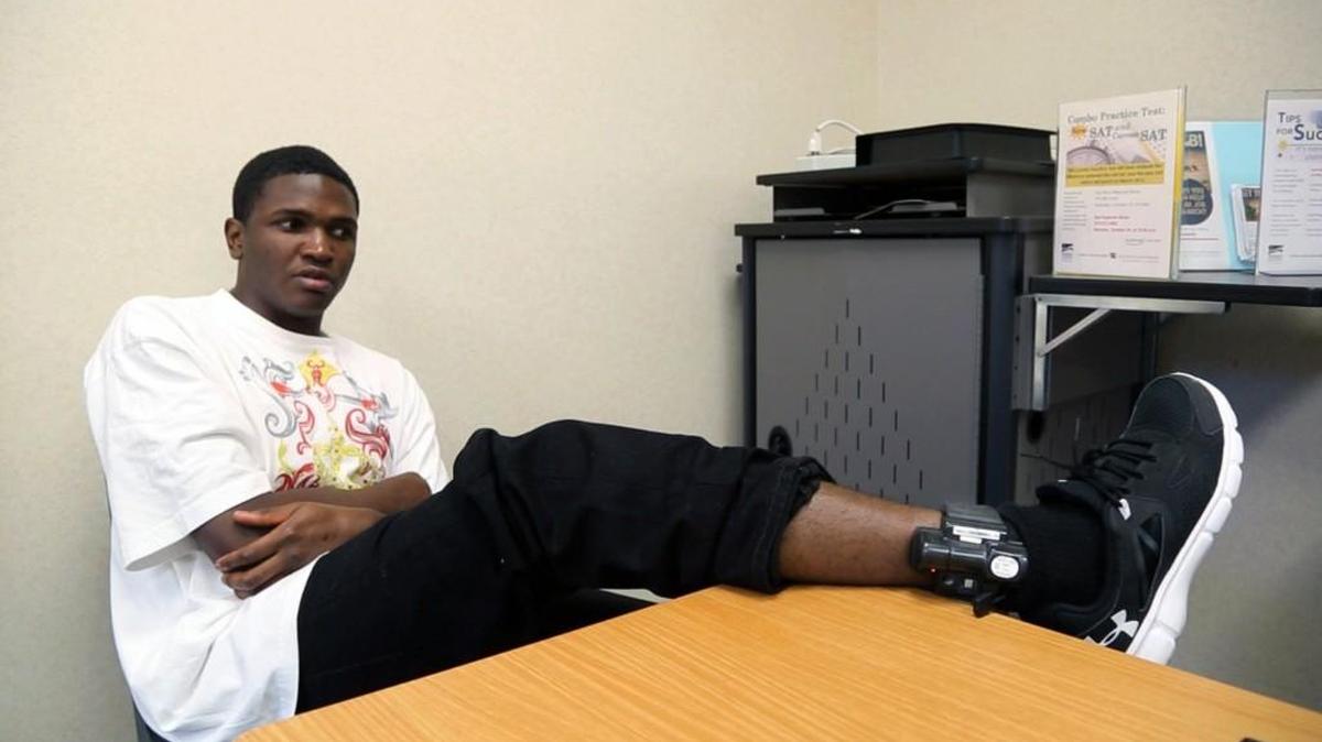 Devon Davis shows off an ankle monitor during an interview. Davis spent 1,001 days, in the North Carolina prison system in solitary confinement. Since his release last year, he's had trouble reconnecting with his family and finding employment.