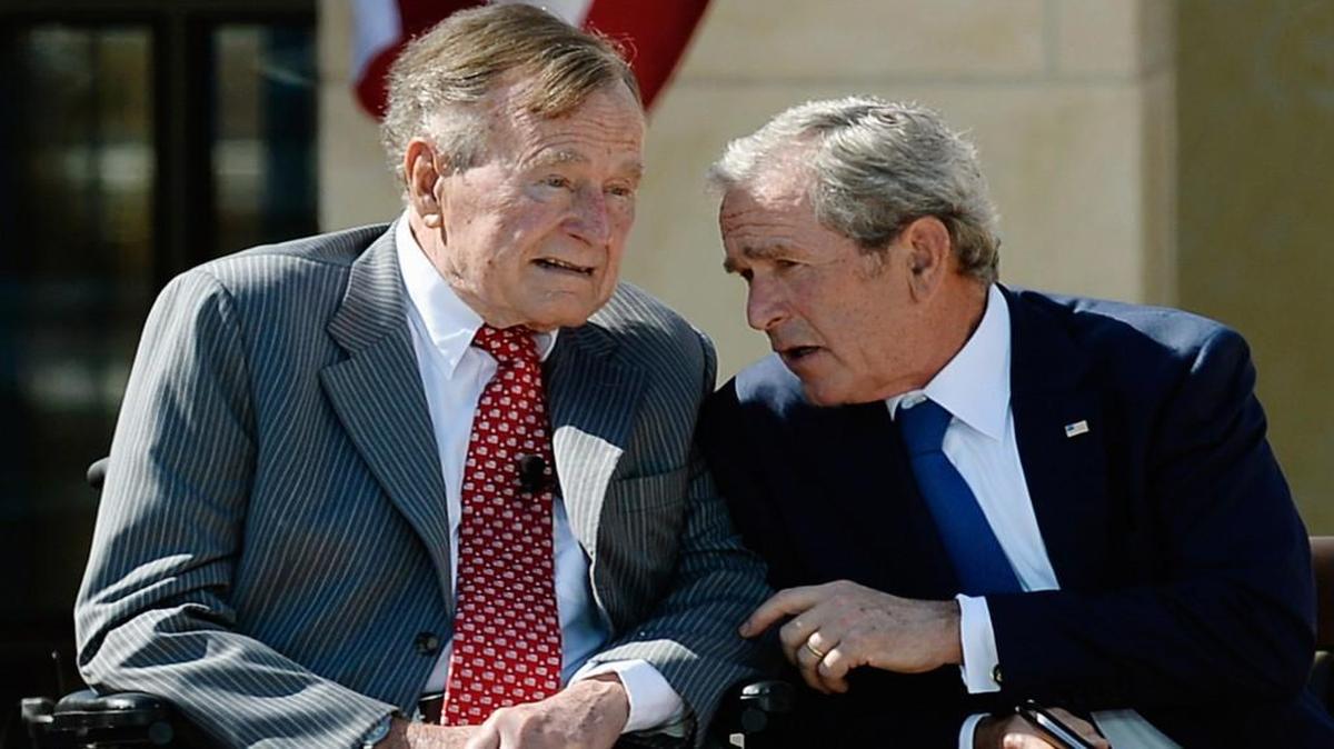 Former President George W. Bush, right, talks to his father President George H.W. Bush during the opening ceremony of the George W. Bush Presidential Center April 25, 2013 in Dallas, Texas.