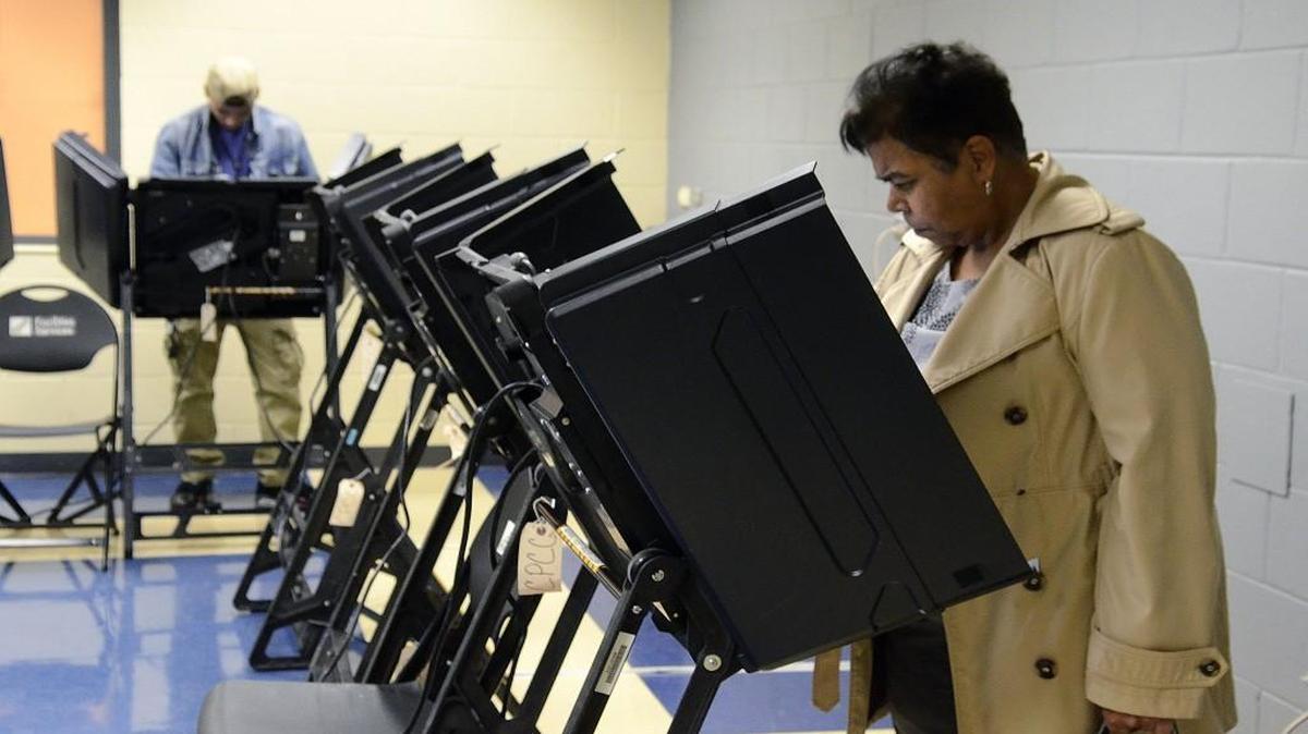 In this file photo, two voters cast their ballots at the Central Piedmont Community College Facilities Services building in Charlotte. Starting in 2023, North Carolina began requiring every voter to present a state-approved photo ID to vote.