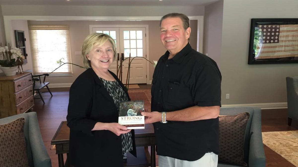 Hillary Clinton and Rev. Bill Shillady with “Strong for a Moment Like This,” a book of devotionals Shillady and others wrote for Clinton during the 2016 presidential campaign.