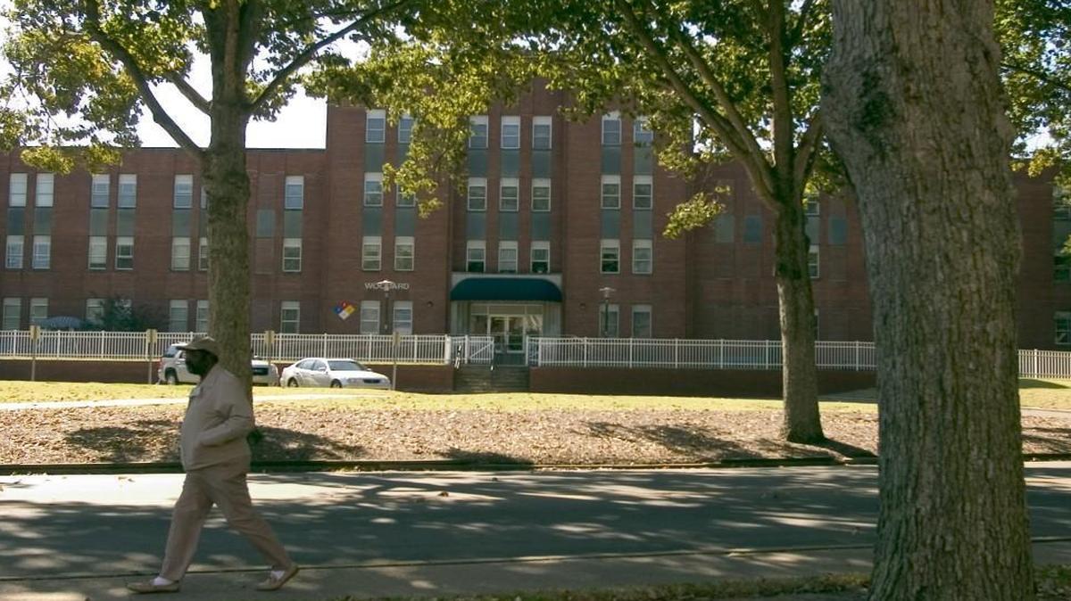 A passerby walks through the Cherry Hospital campus.