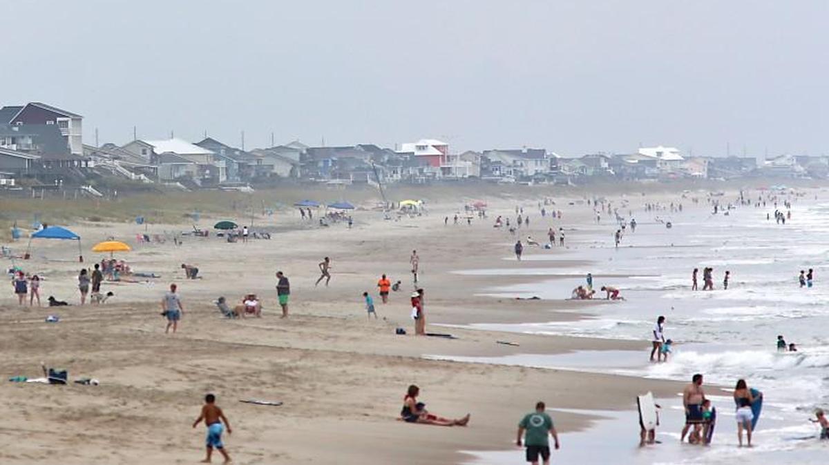 Beach-goers on Emerald Isle July 13, 2015. A lawsuit filed by beachfront property owners at Emerald Isle asks the N.C. Supreme Court to overturn a unanimous decision by the state Court of Appeals late last year that upheld an Emerald Isle ordinance barring beachfront property owners from putting any beach equipment or structures “within an area 20 feet seaward of the base of the frontal dunes.”