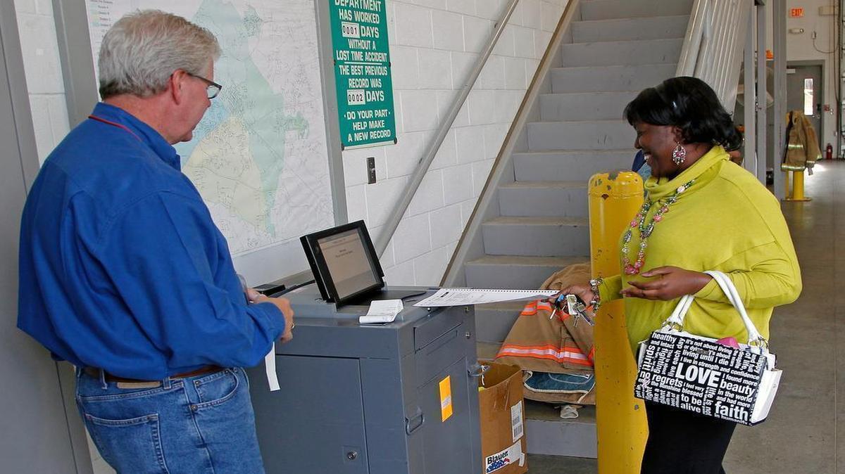 
Poll worker Robert Capps, left, watches as Cynthia Toudle, right, inserts her ballot in the voting machine at Johnston County Precinct 10a at the Clayton Fire Station in Clayton on Nov. 5, 2014.
