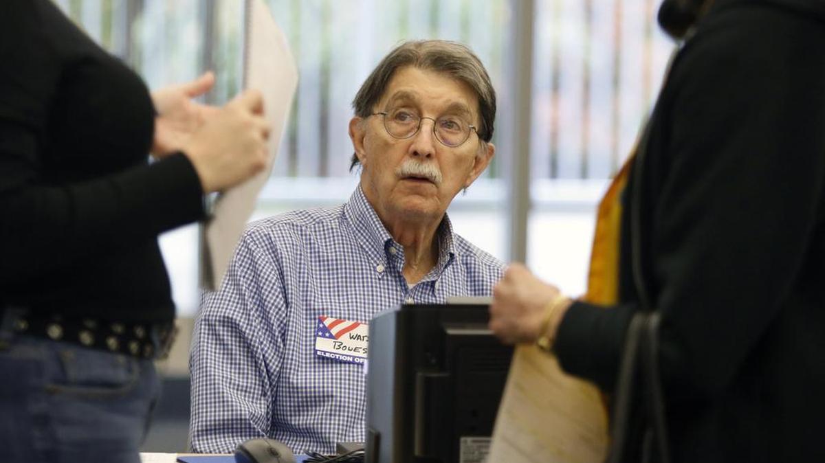 Estes Hills precinct election official Watson Bowes listens as fellow official Calyx Harris, left, helps a voter with her voter ID situation after the voter came to the wrong precinct to vote Tuesday, November 3, 2015. Tuesday was Orange County municipal elections day also with voting for school board offices and five bond referendums. Voter turnout among the approximately 2,400 registered voters in Chapel Hill's Country Club percent was the second highest in the Chapel Hill area with 224 early or absentee voters, and 162 voting Tuesday in the first four hours of the day since 630am opening.