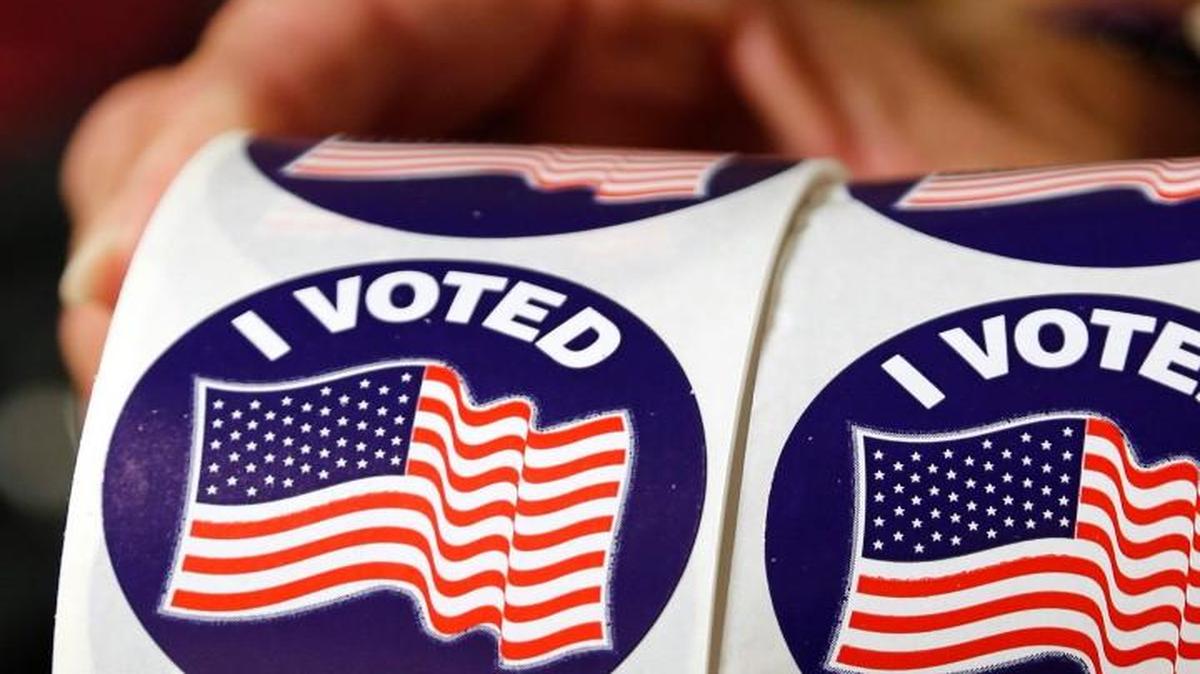 Voters are offered a sticker as they cast their ballots on the first day of early voting at the Hope Mills Recreation Center in Hope Mills, NC on Oct. 20, 2016.