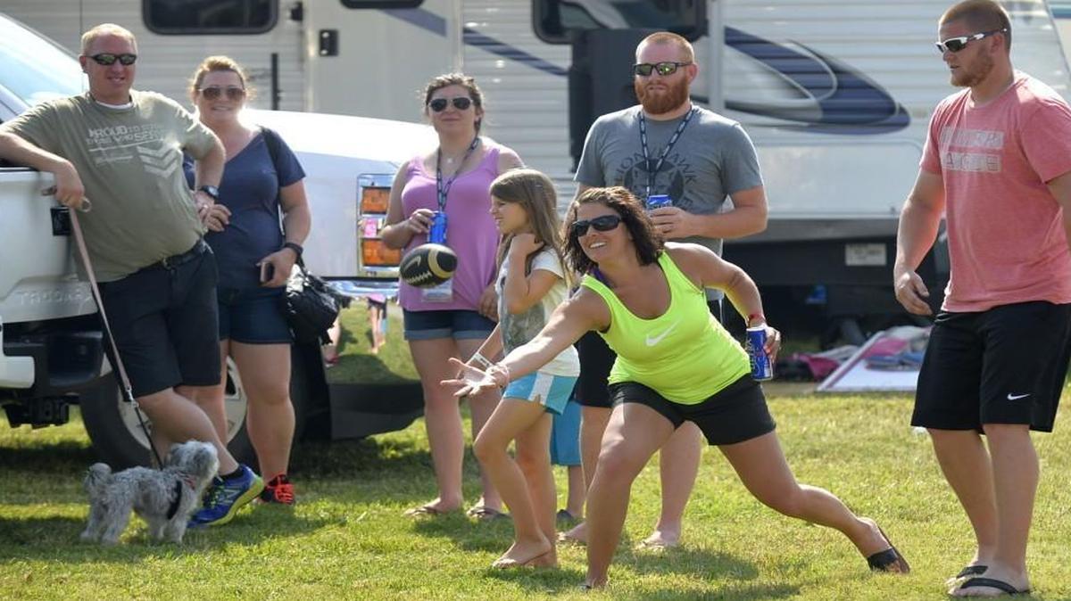 Ashley Bowman, center, and her husband, Jerry Bowman, right, play a family game of catch Friday at Charlotte Motor Speedway. While Ashley Bowman’s political views are not known, many women at the track said they favor Republican presidential candidate Donald Trump over Democrat Hillary Clinton.