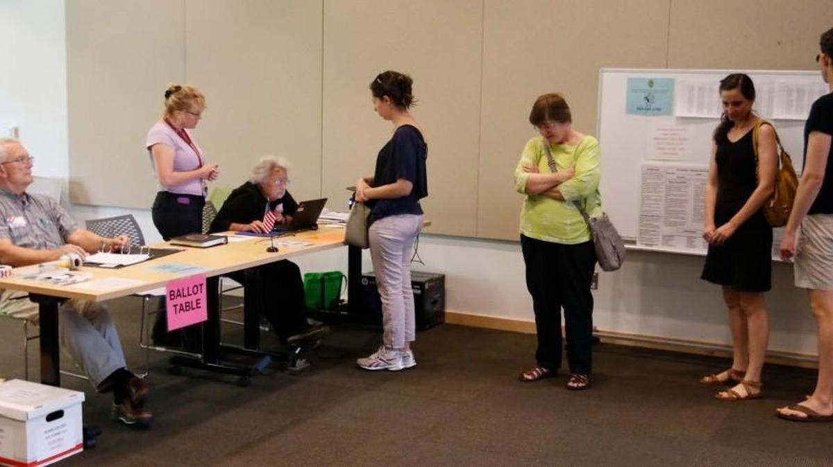 From left, Estes Hills precinct workers Barron Housel, Chief Judge Calyx Harris and Karen Piplani help check voters in during primary-election voting Tuesday, June 7, 2016 at the Chapel Hill Public Library.