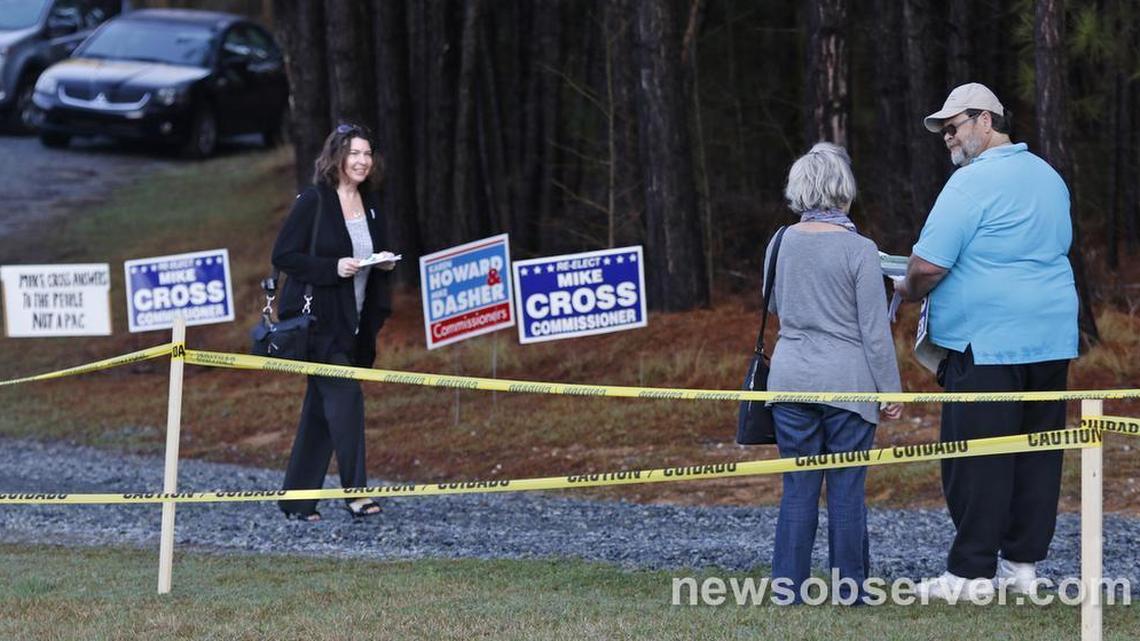 A Chatham County voter at left leaves the polling place at Perry Harrison Elementary School on March 15, 2016, as another voter on her way in to vote stops to get printed information.
