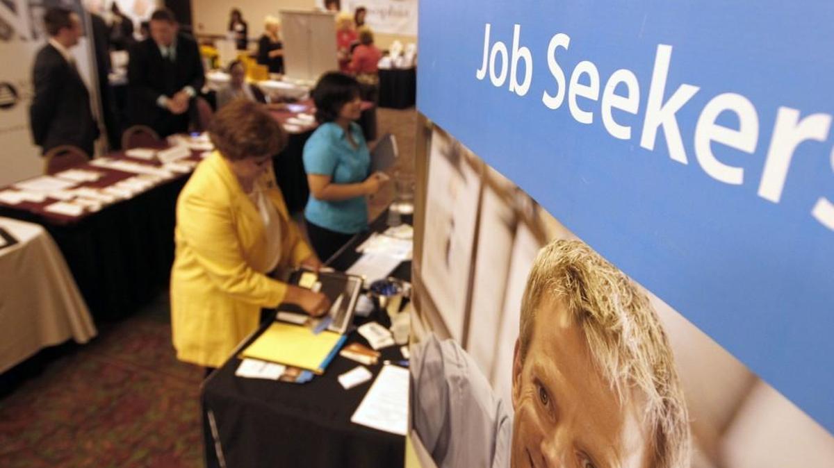 People walk by the recruiters at a jobs fair in Green Tree, Pa., in 2012.