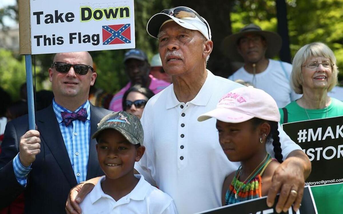 
Walter Tobin stands with his grand-children Jack Tobin and Bishop Tobin (right) as they show their support for the removal of the confederate flag from the Capitol grounds, during a protest in support of the flags removal on June 23, 2015 in Columbia, South Carolina. South Carolina governor Nikki Haley asked that the flag be removed after debate over the flag flying on the capitol grounds was kicked off after nine people were shot and killed during a prayer meeting at the Emanuel African Methodist Episcopal Church in Charleston, South Carolina. 
