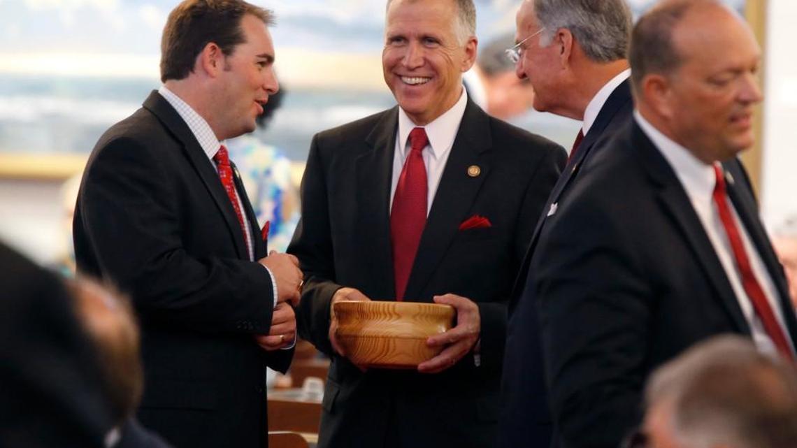 House Speaker Thom Tillis talks with Reps. John R. Bell IV, left, and Ted Davis, Jr., right, while passing out candy before the convening of the House during opening day of the General Assembly in 2014.
