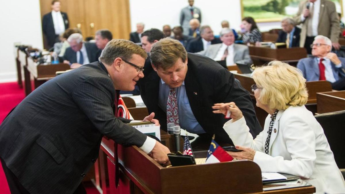 NC House Speaker Tim Moore, left, talks with leading House budget writers, Reps. Nelson Dollar and Linda Johnson during a 2015 House session.
