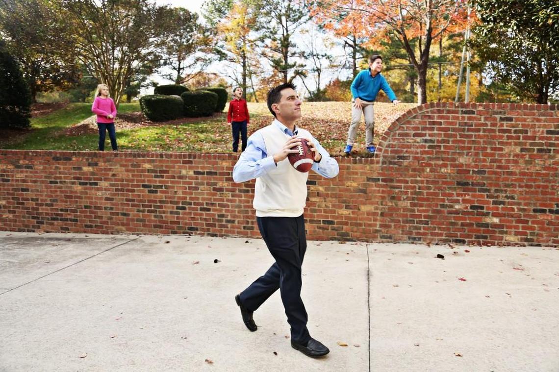 Dallas Woodhouse spots his brother, Brad, on their mother's balcony in Raleigh and decides to throw the football up to him as his sons and niece cheer the two on Thanksgiving, Nov. 23, 2017.