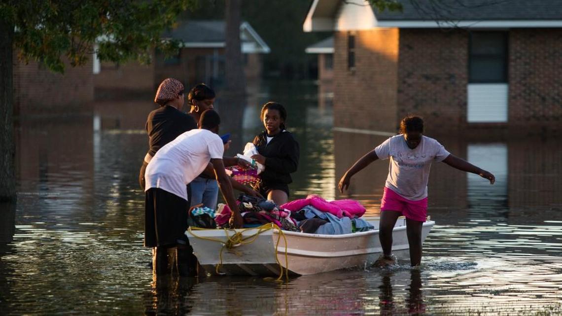 Residents return from checking their homes after Hurricane Matthew caused downed trees, power outages, a municipal water outage and widespread flooding along the Lumber River Thursday, October 13, 2016 in Lumberton, NC.