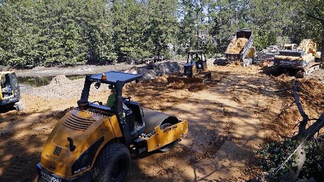 Several dams failed following the flooding caused by Hurricane Matthew. One dam was washed away and another was threatened but still standing in a compromised state at the J.C. Keith Lake, affecting the surrounding Rayconda neighborhood in Fayetteville. Here workers rebuild the upper dam on Siple Avenue while residents use the precarious lower dam on Oct. 19.