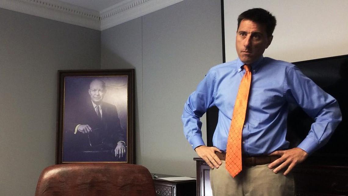 Dallas Woodhouse, executive director of the North Carolina Republican Party, stands next to a portrait of former president and Army general Dwight Eisenhower as he gets an update from his staffers about campaign mailers and fundraising efforts.