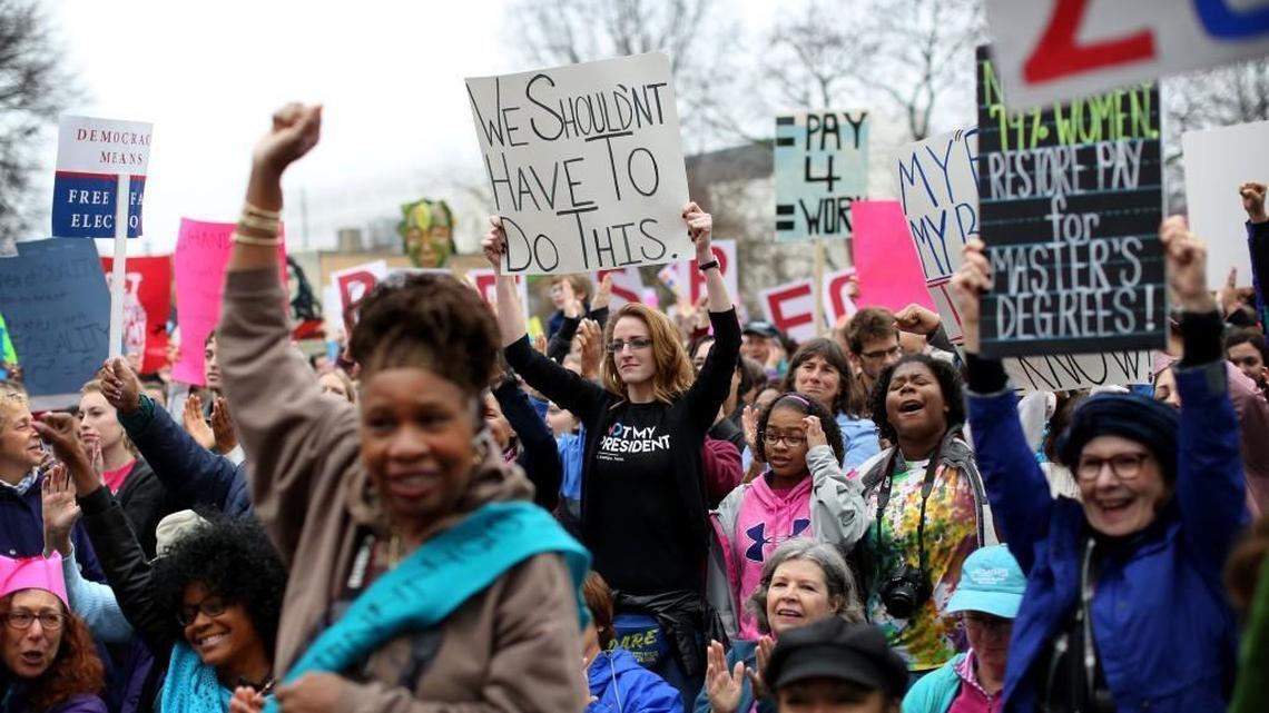 Daria Caruso, center, holds up a sign during the Women's March on Raleigh in downtown Raleigh on Jan. 21, 2016.