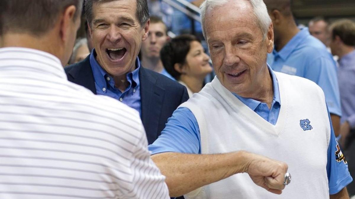 North Carolina Gov. Roy Cooper and UNC coach Roy Williams greet UNC-Wilmington coach C.B. McGrath prior to the North Carolina Disaster Relief Jamboree on Nov. 5, 2017 at the Smith Center in Chapel Hill, N.C.