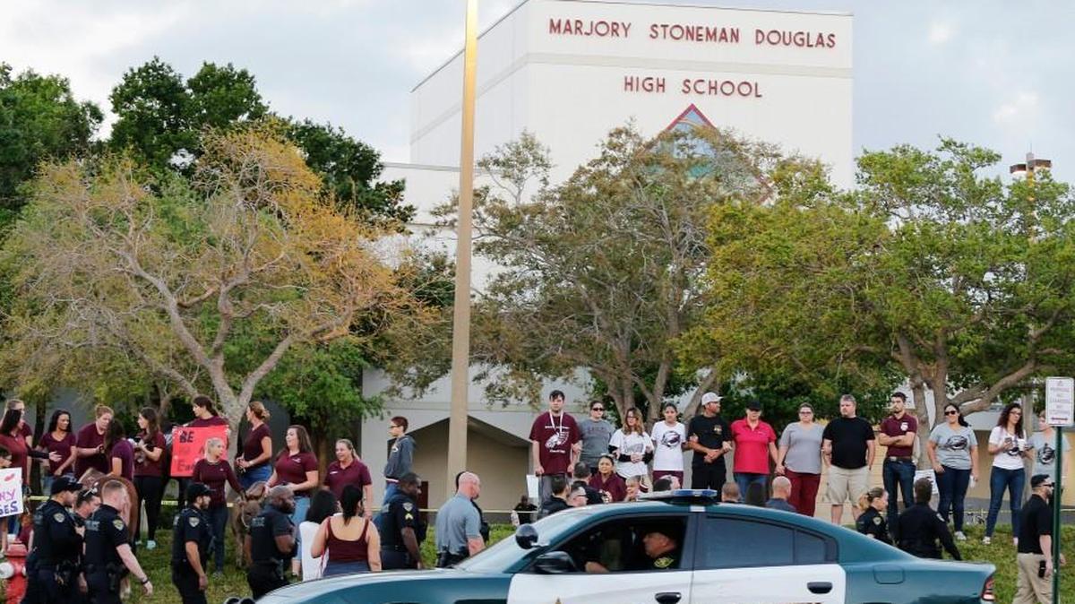 In this Feb. 28, 2018 photo, a police car drives by Marjory Stoneman Douglas High School in Parkland, Fla., as students returned to class for the first time since a former student opened fire there with an assault weapon.