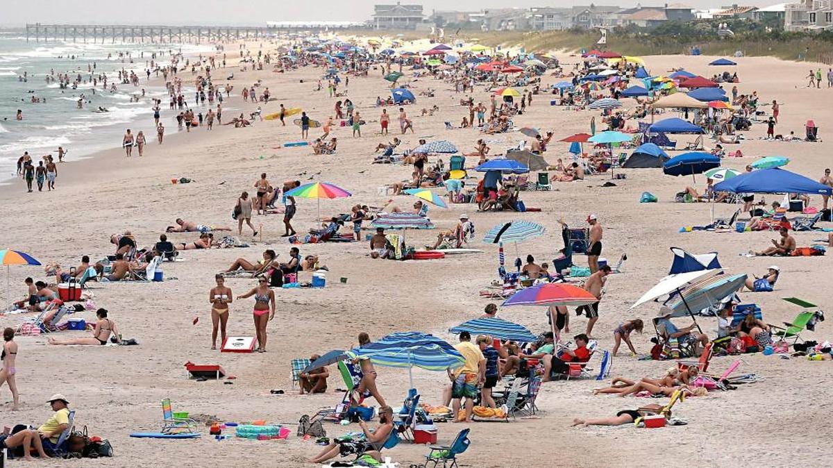 The beach stand looking south from the Johnny Mercer pier at Wrightsville Beach, NC on July 2, 2015 is crowded with thousands of vacationers. The school calendar law was passed with the support of the tourism industry, which was worried about how schools were shortening summer break.