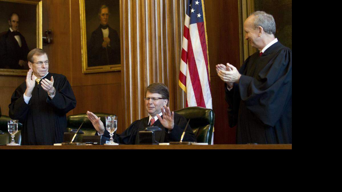 
Chief Justice Mark Martin, center, gestures for Justice Robert Edmunds, left, and Paul Newby, right, to cease their applause as he takes his seat after he was sworn in as the Chief Justice of the N.C. Supreme Court in January. A bill passed in the N.C. House Thursday would make judicial elections partisan.
