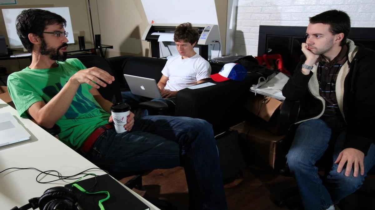 WedPics staff Jon Williams, left, and Forest Belton, right, talk while David Cullen uses a laptop computer. The local start-up created a photo-sharing app. that allows attendees to take photos at a wedding with their smartphone and upload them all to a center place. WedPics co-founder Andrew Heymann is among 170 entrepreneurs who signed a petition opposing House Bill 2.