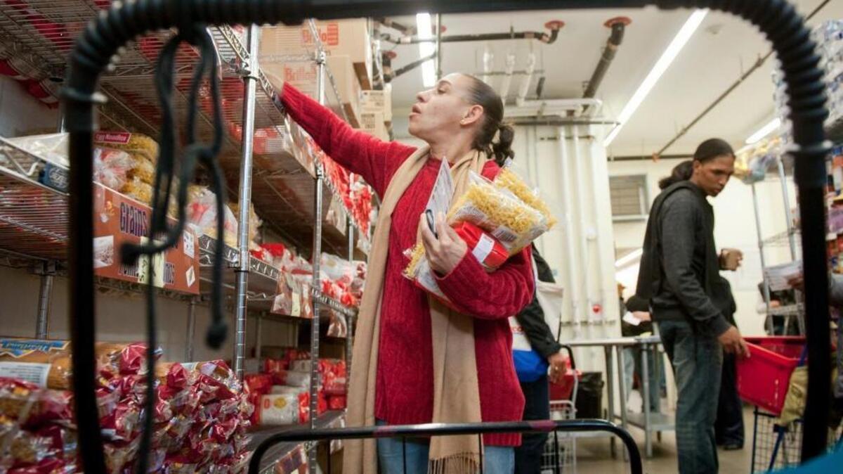 In this file photo, Ingrid Mock picks up items from the food pantry at Part of the Solution, a nonprofit organization, in New York, on Nov. 4, 2013.